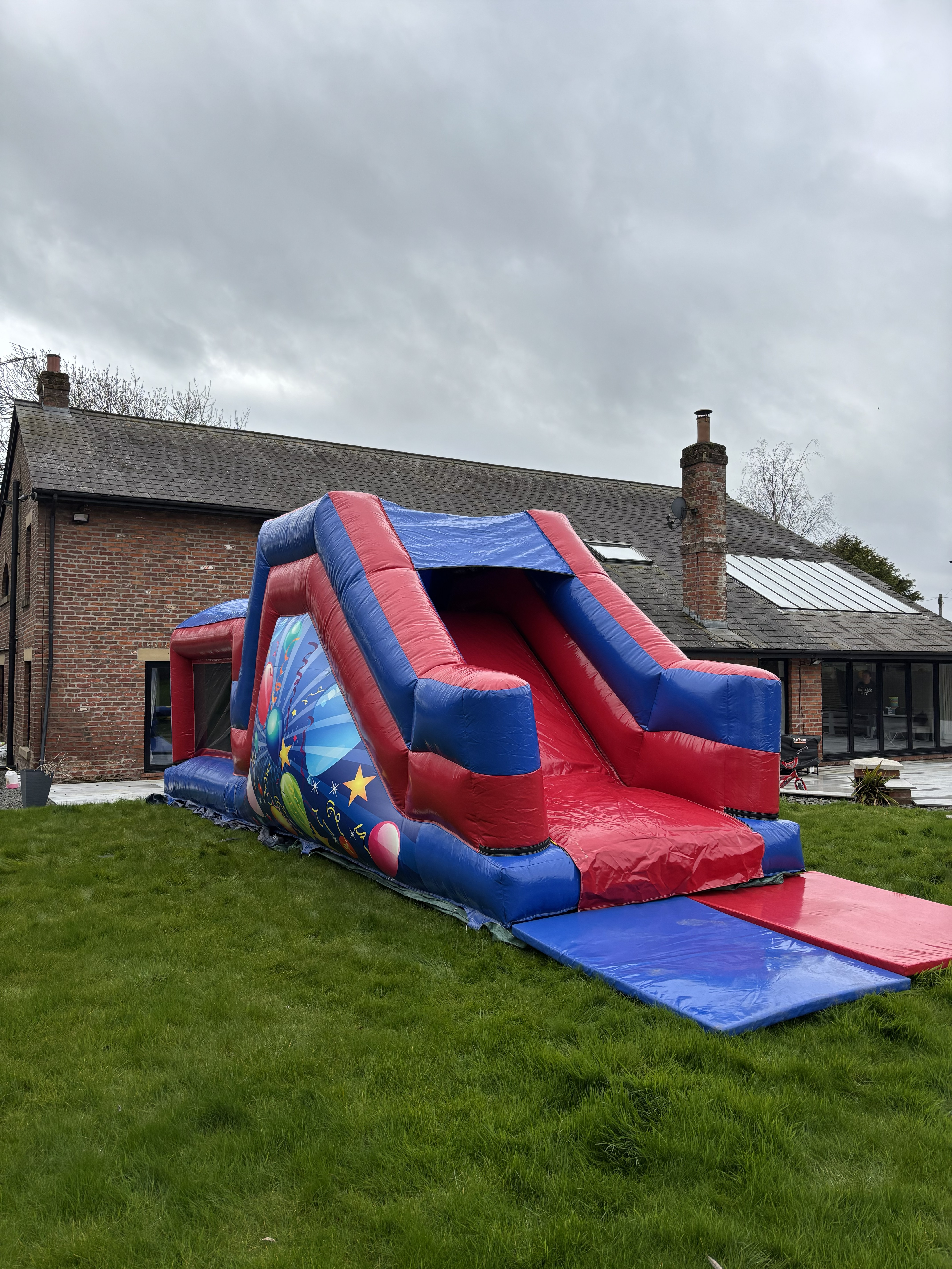 Giant inflatable assault course setup for a garden party in Weeton by Fylde Coast Bouncy Castles.